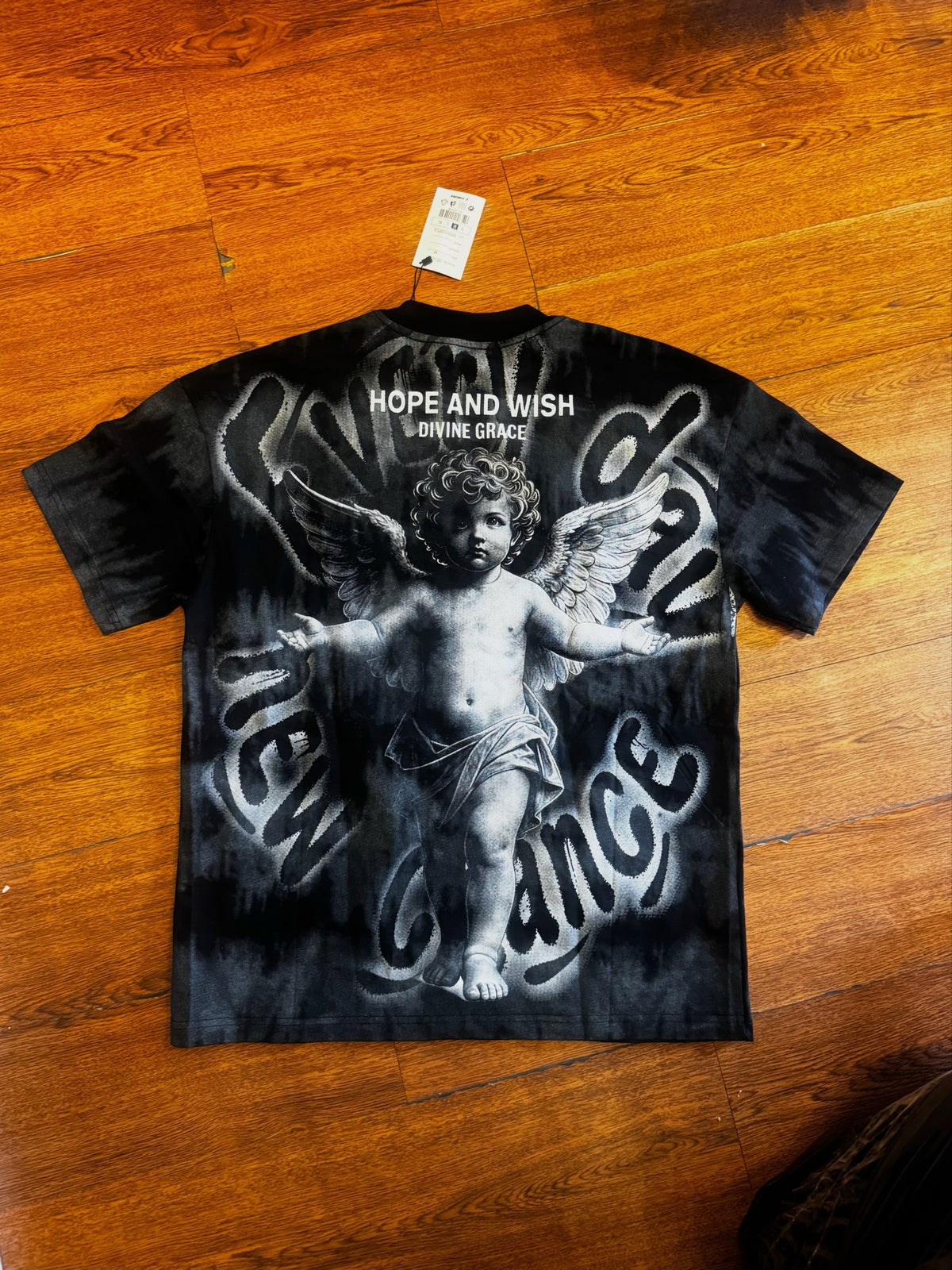 Playera Querubín Deslavada en negro, con querubín y frase Hope and Wish en la espalda