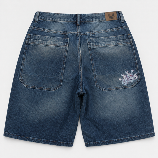 Short baggy Perro Negro de mezclilla índigo lavado, vista trasera con bolsillos amplios y bordado.